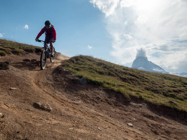 istock Man mountain biker rides along trail below the Matterhorn mountain 1314549499