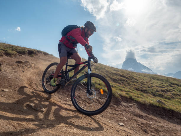 istock Man mountain biker rides along trail below the Matterhorn mountain 1314549994