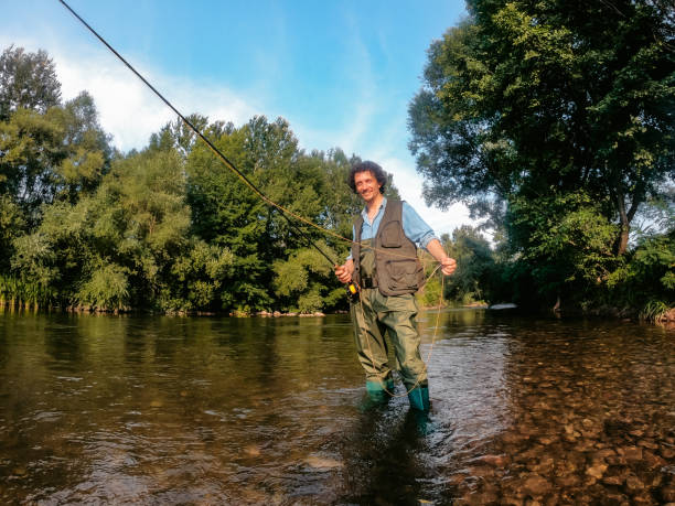 istock Fisherman fishing in a forest river 1314550068
