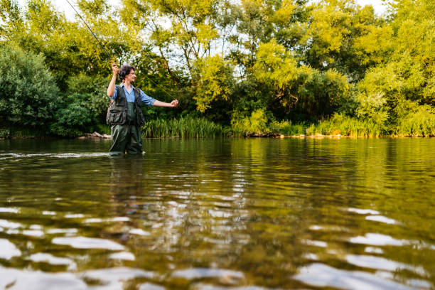 istock Fisherman fishing in a forest river 1314550103