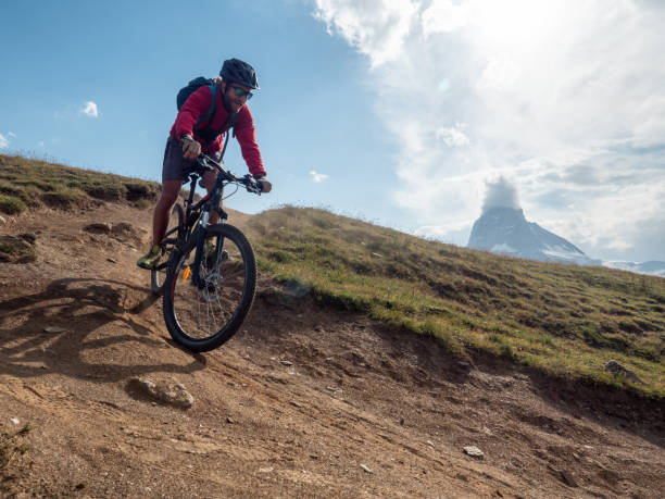 istock Man mountain biker rides along trail below the Matterhorn mountain 1314550842