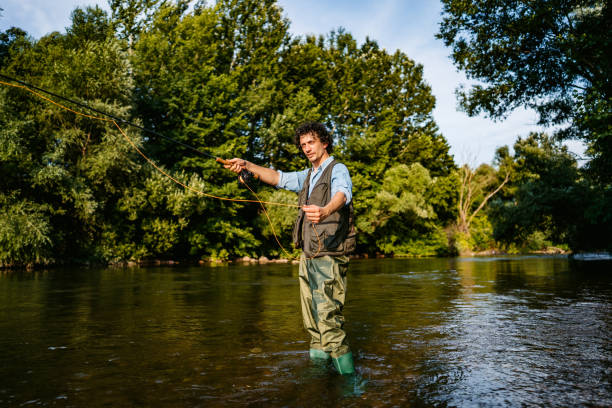 istock Fisherman fishing in a forest river 1314551173
