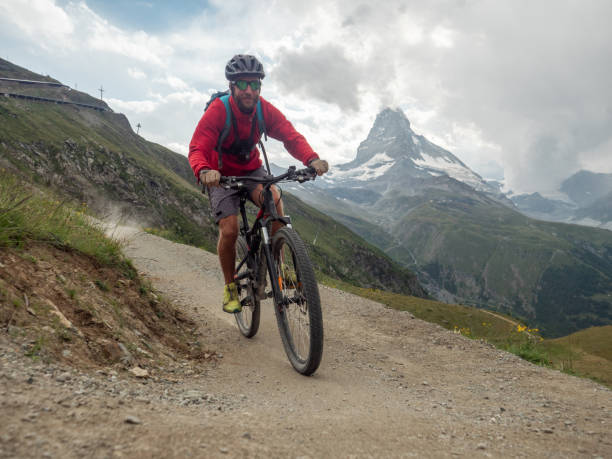istock Man mountain biker rides along trail below the Matterhorn mountain 1314551459