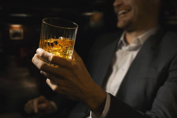 szczęśliwy biznesmen ze szklanką whisky w klubowym barze dżentelmenów - whisky alcohol glass party zdjęcia i obrazy z banku zdjęć