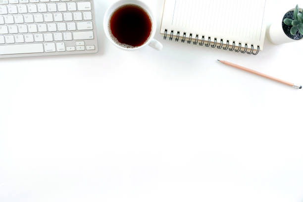istock Modern white office desk table with laptop computer, smartphone with black screen over a notebook and cup of coffee. Top view with copy space, 1314552968