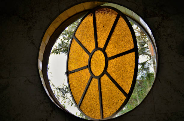 A circular window with ambar color glass decorating cottage