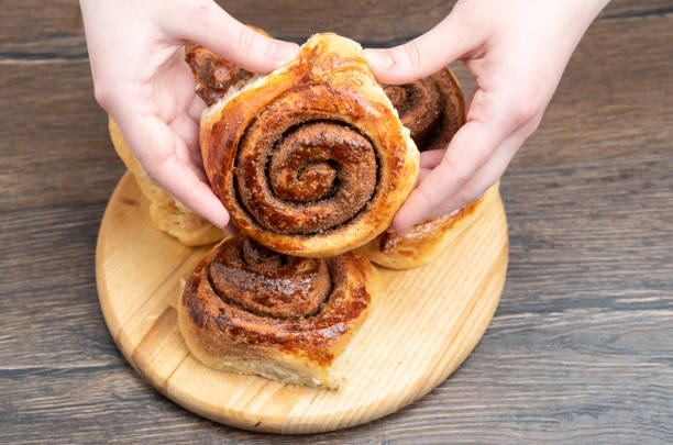 istock Freshly baked cinnabon cinnamon roll in female hands. 1314556326