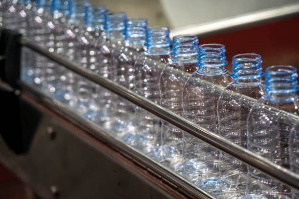 飲料水工場で充填プロセスのための�コンベアベルト上のpetボトル。 - bottling plant bottle filling production line ストックフォトと画像