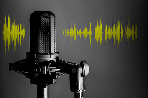 Micrófono de estudio profesional sobre fondo oscuro con forma de onda de audio amarillo, Podcast o banner de estudio de grabación musical photo
