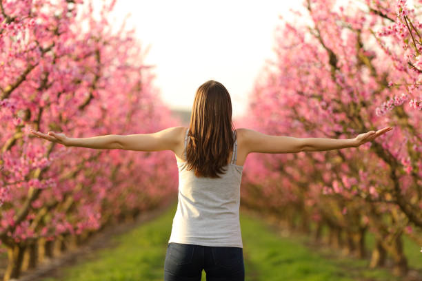 istock Lady stretching arms celebrating spring in a pink field 1314559193