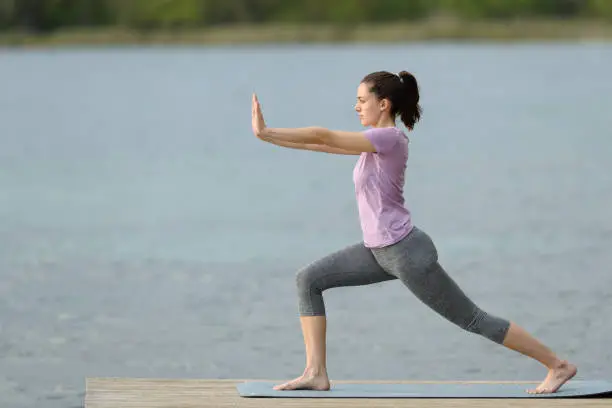 Photo of Side view of a woman doing tai chi exercise in a lake