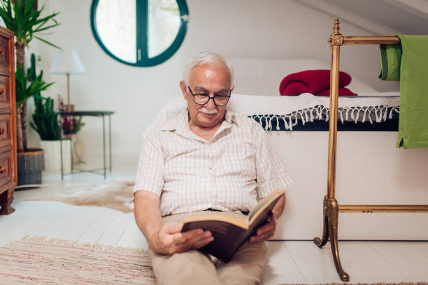 istock Senior man reading a novel and relaxing on the floor 1314563053