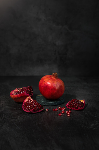 Pomegranate Fruits cut open with seeds on dark background