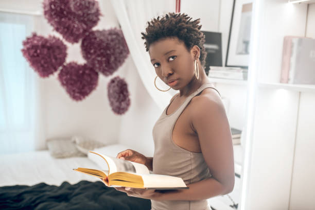 istock Elegant good-looking dark-skinned woman with a book in hands 1314565761