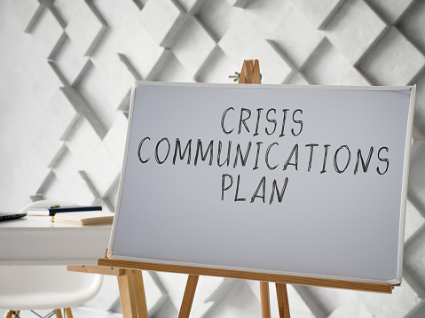 Crisis Communications Plan written on the white desk.