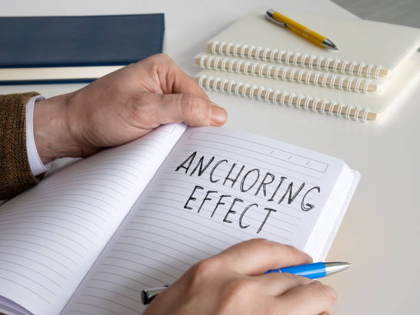 istock Man writes about anchoring effect or cognitive bias in the notepad. 1314568760