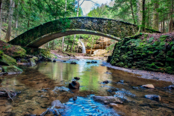 waterfall as seen through arched bridge - arch bridge imagens e fotografias de stock