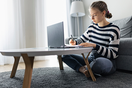 Teenage girl during COVID-19 lockdown attending to online class from home. The school has been closed during coronavirus outbreak and the classes have moved to e-learning platform.
Shot with Canon R5