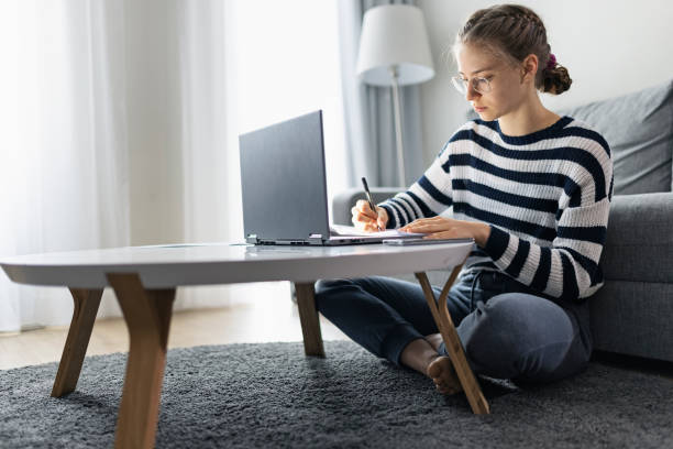 Teenage girl attending online class from home. Teenage girl during COVID-19 lockdown attending to online class from home. The school has been closed during coronavirus outbreak and the classes have moved to e-learning platform.
Shot with Canon R5 kid sitting cross legged stock pictures, royalty-free photos & images