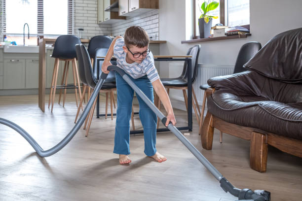 istock A little boy vacuums the room under the couch. 1314572491