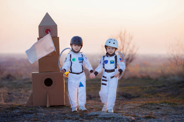 istock Two adorable children, playing in park on sunset, dressed like astronauts 1314573084