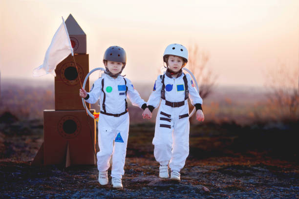 istock Two adorable children, playing in park on sunset, dressed like astronauts 1314573106