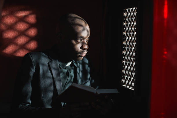 sacerdote leyendo la biblia en la iglesia - confession booth fotografías e imágenes de stock