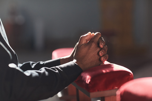 Close-up of African man praying in front of the altar in the church