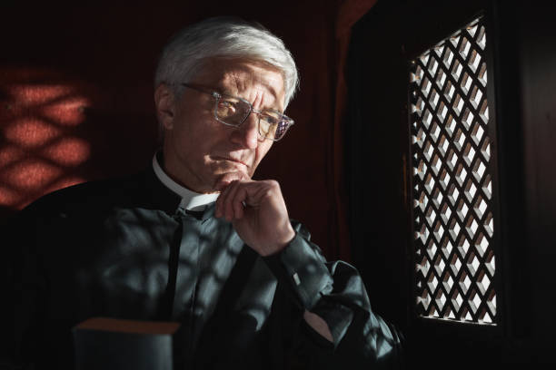 sacerdote escuchando la confesión - confession booth penance catholicism church fotografías e imágenes de stock