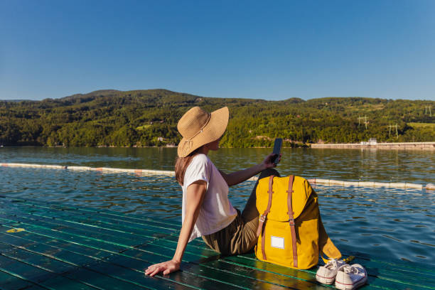 istock Woman with backpack relaxing by the lake and looking at view 1314576380