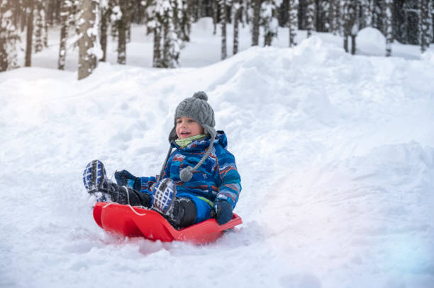 istock Boy tobogganing on snowy landscape 1314576505