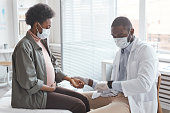 Doctor measuring the pulse of pregnant woman