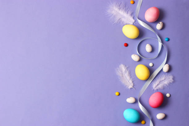 istock Easter composition of painted eggs and feathers on a colored background. 1314577427