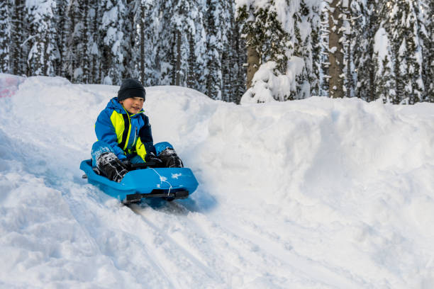 istock Boy tobogganing on snowy hill 1314579201