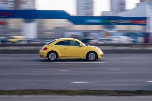 Ukraine, Kyiv - 21 March 2021: Yellow Volkswagen Beetle car moving on the street. Editorial