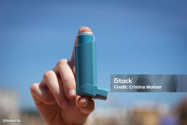 Human Hand Picking Up An Asthma Inhaler Stock Photo - Download Image Now - Asthma Inhaler, Cut Out, Asthmatic