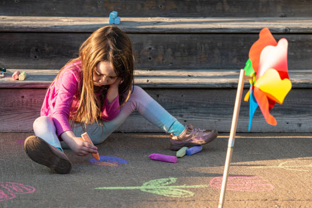 istock Girl Makes Chalk Drawing Front Porch 1314583981