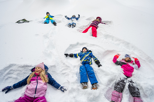 High angle view of boys and girls making snow angles.