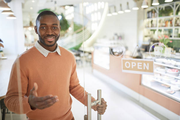 istock Smiling Man Welcoming Guests to Cafe 1314584322