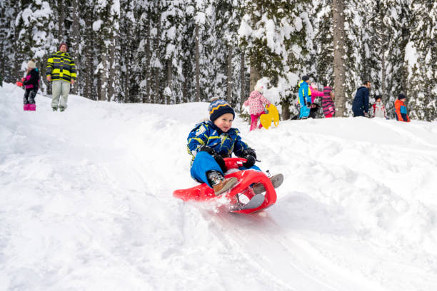 istock Boy tobogganing on snowy hill 1314584373