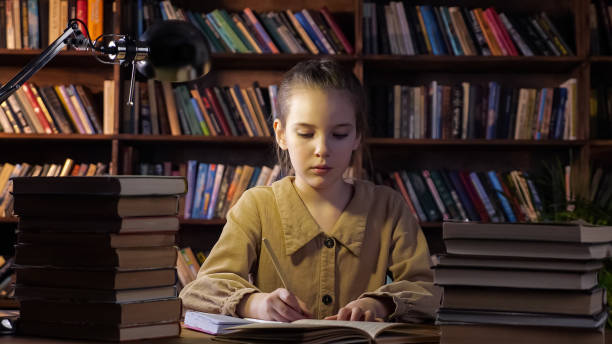 istock Exhausted young lady writes home assignment in copybook 1314585868