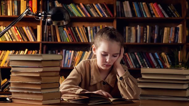 istock Young lady in brown jacket reads training materials in book 1314585873