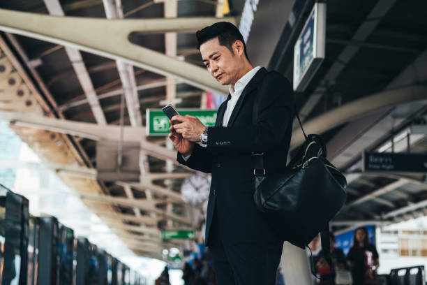 istock Business man using phone and waiting train 1314586116