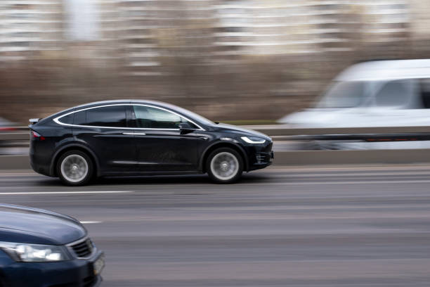 Black TESLA Model X car moving on the street. Ukraine, Kyiv - 18 March 2021: Black TESLA Model X car moving on the street. Editorial tesla model x stock pictures, royalty-free photos & images