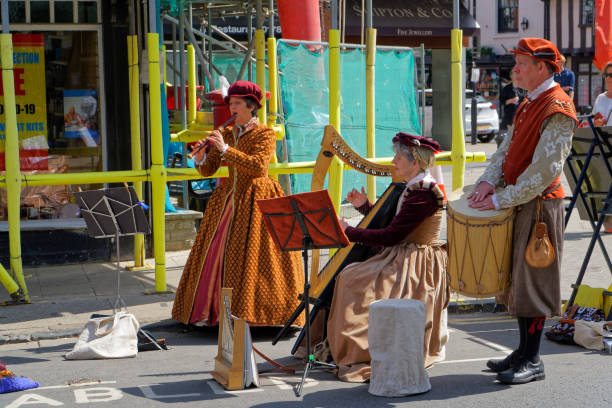 Three musicians in period costumes, playing the flute, harp and drum in Stratford-upon-Avon, April 24, UK 2021 Three musicians in period costumes, playing the flute, harp and drum in Stratford-upon-Avon, April 24, UK 2021 warwick uk stock pictures, royalty-free photos & images