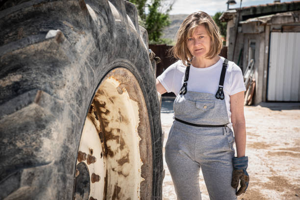 istock Female mechanic resting from workday on truck wheel 1314590198
