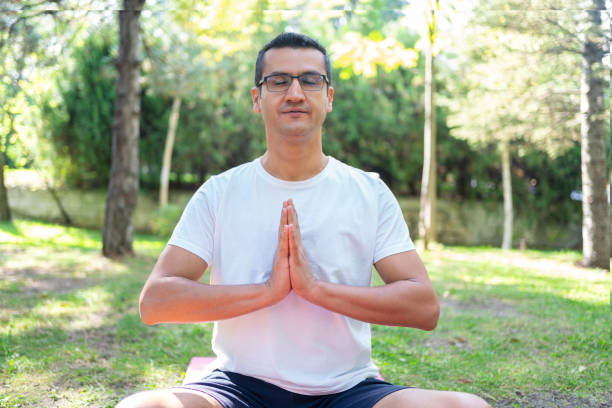 istock Young man practicing yoga in the park 1314591158
