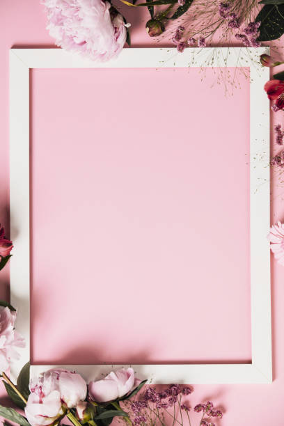 istock Assorted pink flower and white frame border on pink background, flat lay 1314591909