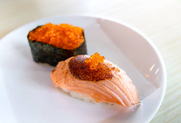 Salmon sushi grill top with sweet miso by indoor low and warm lighting.