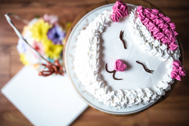 Top view of white, cream cake with cat decoration